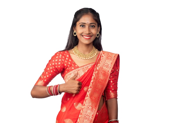 Traditional young smiling girl showing ok sign or thumbs up on a white background