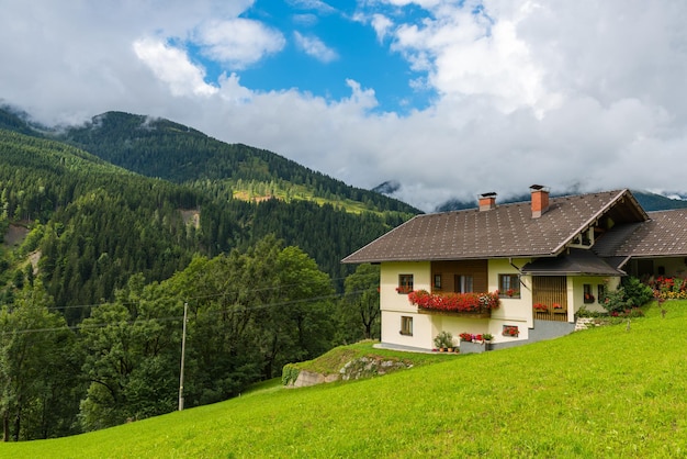 Traditioneel alpenhuis in groene bosbergen