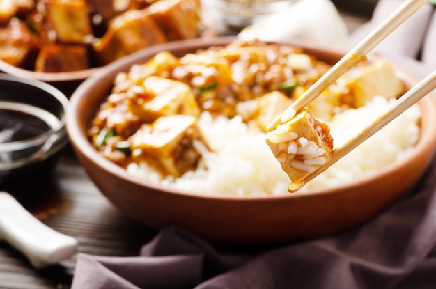 Traditioneel Chinees eten mapo tofu gerecht met varkensvlees en gestoomde rijst in eetstokjes