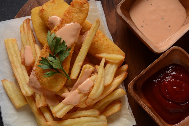 Traditioneel Engels eten - Fish and Chips. Gebakken visfilets en krokante frietjes geserveerd met ketchup en huisgemaakte tartaarsaus.