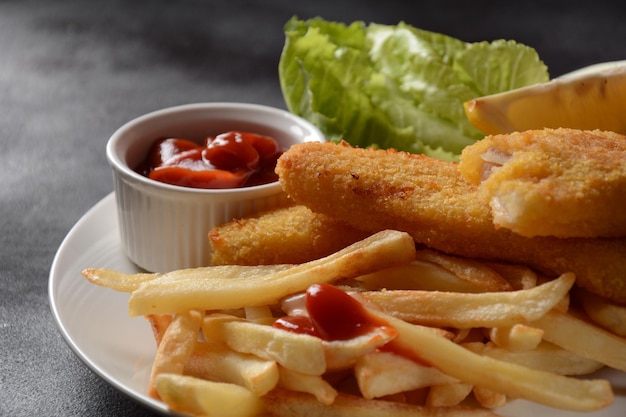 Traditioneel Engels eten - Fish and Chips. Gebakken visfilets en krokante frietjes geserveerd met ketchup en huisgemaakte tartaarsaus.