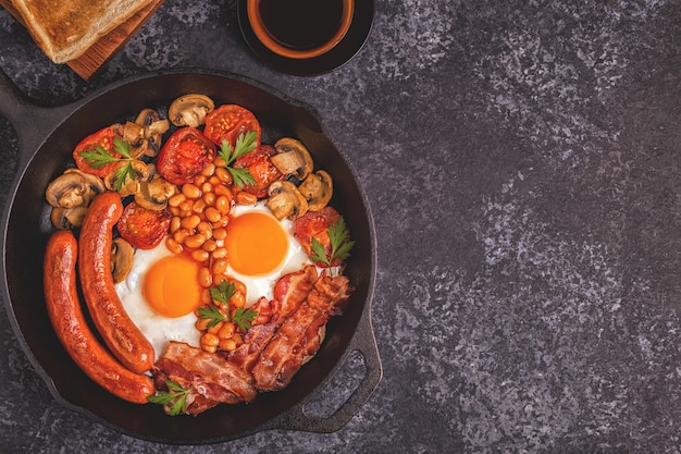 Traditioneel Engels ontbijt met gebakken eieren, worstjes, bonen, champignons, gegrilde tomaten en spek