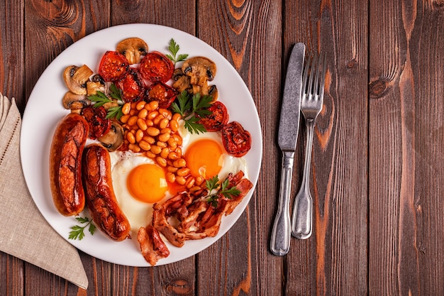 Traditioneel Engels ontbijt met gebakken eieren, worstjes, bonen, champignons