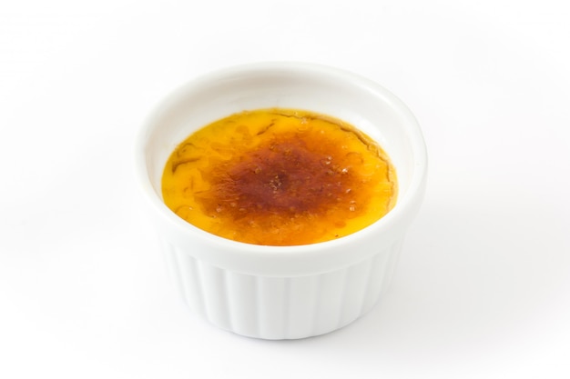 Traditioneel frans room brulee dessert met gekarameliseerde suiker die op wit wordt geïsoleerd.