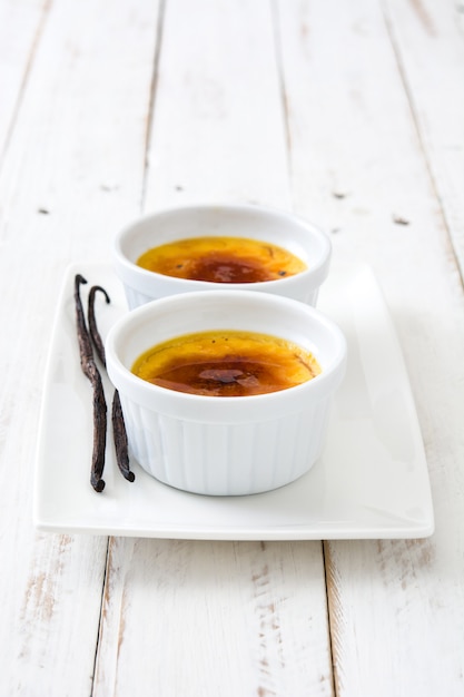 Traditioneel frans room brulee dessert met gekarameliseerde suiker op bovenkant, op houten lijst