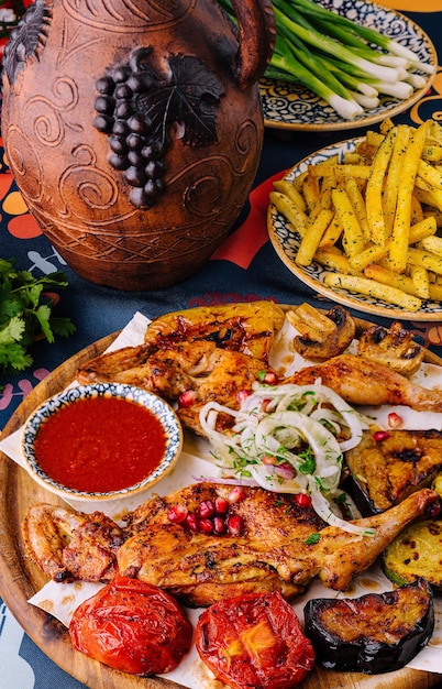 Traditioneel gegrilde kippenplaat met groenten en specerijen