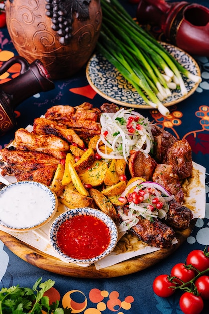 Traditioneel gegrilde vleesplaat met bijgerechten en sauzen