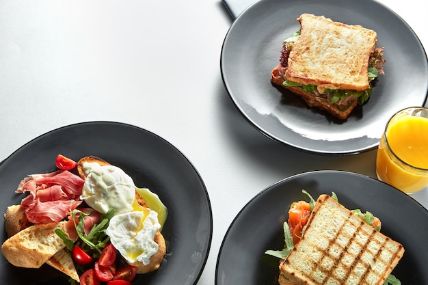 Traditioneel hotel Ontbijt geserveerd aan tafel met ham en tomaat, toast, Benedictus-eieren, sinaasappelsap