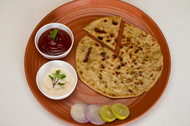 Foto traditioneel indiaas eten aloo paratha of aardappel gevuld plat brood. geserveerd met tomatenketchup