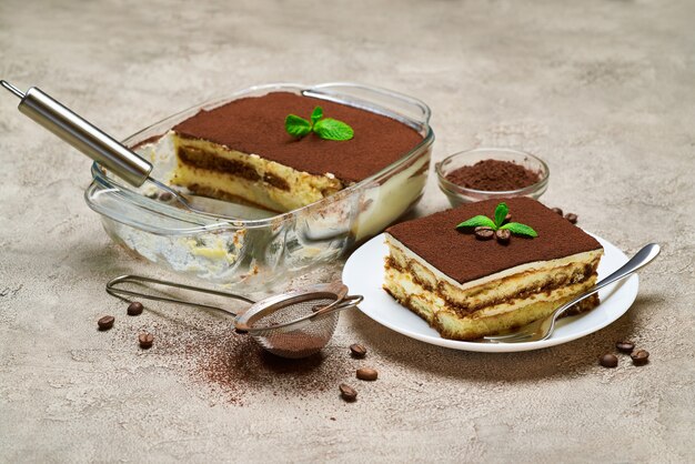 Foto traditioneel italiaans tiramisu-dessert in een glazen ovenschaal en een gedeelte