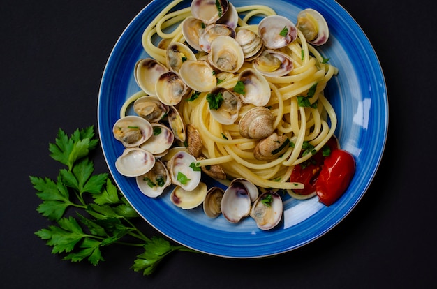 Traditioneel Italiaans zeevruchtenconcept. Spaghetti met kokkels of plankish, tomaat en kruiden