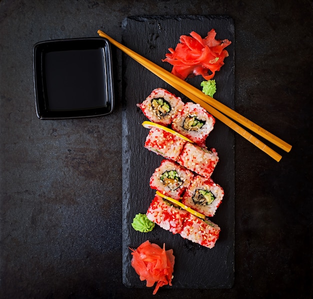 Traditioneel Japans eten - sushi, broodjes en saus op een zwarte achtergrond. Bovenaanzicht