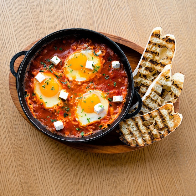 Foto traditioneel joods ontbijt als roerei gepocheerde eieren in een pittige tomaten-pepersaus