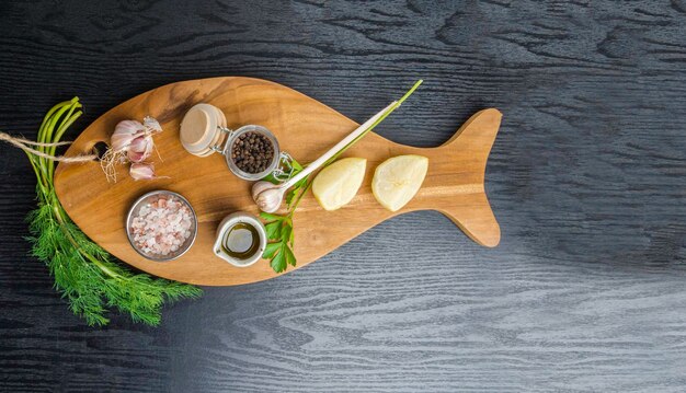 Traditioneel koken ingrediënten citroen knoflook olijfolie Himalaya zout peper verse kruiden op zwarte houten achtergrond Voedsel frame concept voor het koken van gezond voedsel met ruimte voor tekst