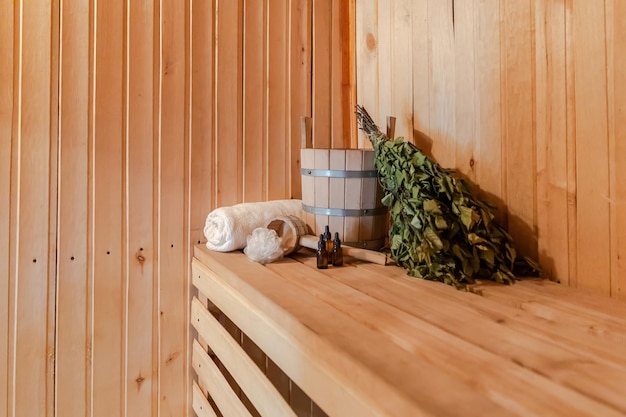 Traditioneel oud Russisch badhuis SPA-concept. Interieur details Finse sauna stoomcabine met traditionele sauna accessoires set wastafel berken bezem handdoek aroma olie. Ontspan het badconcept van het landdorp.