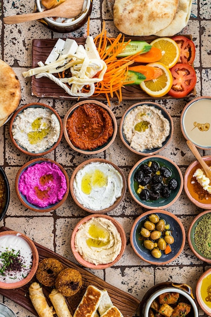 Traditioneel Turks dorpsontbijt op de keramische tafel met gebak, groenten, greens, spreads, kazen, gebakken eieren, jam. Bovenaanzicht.