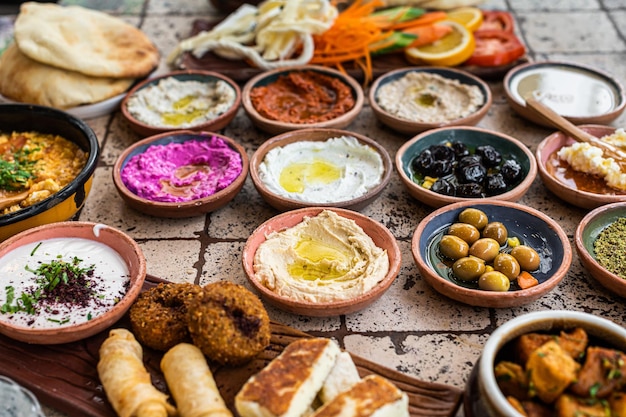 Foto traditioneel turks dorpsontbijt op de keramische tafel met gebakjes groenten greens spreads kazen gebakken eieren jam bovenaanzicht