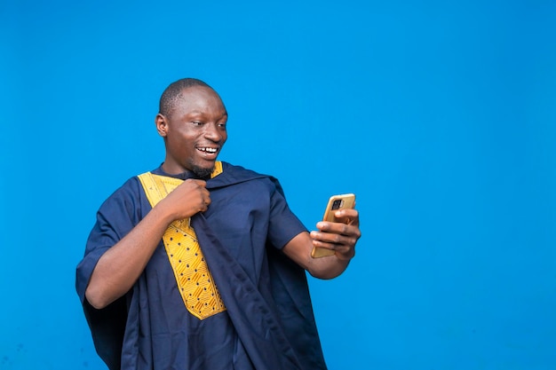 Traditionele Afrikaanse man die mobiele telefoon vasthoudt en bekijkt