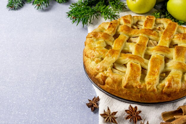 Traditionele appeltaart met appel. In de buurt van de kerstboomtakken