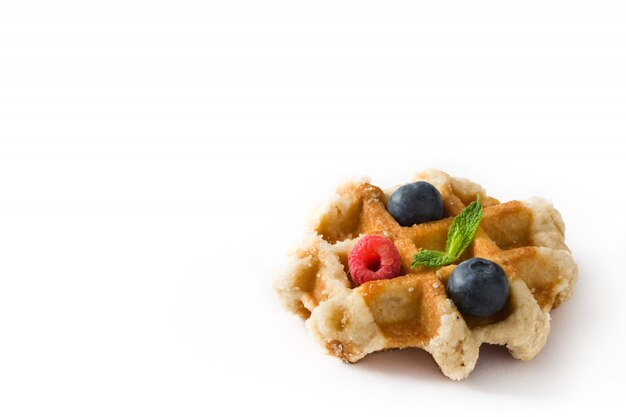 Traditionele Belgische wafel met bosbessen en frambozen geïsoleerd op wit