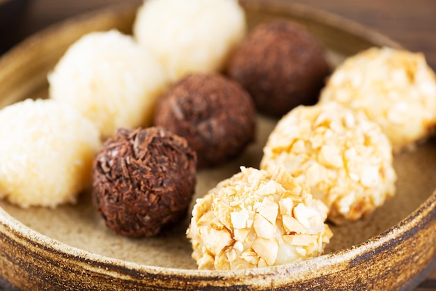 Traditionele Braziliaanse brigadeiro-snoepjes met chocoladekokosnoot en cashewnoten in een zelfgemaakt bord