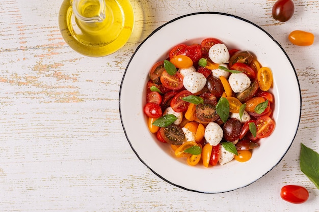 Traditionele Caprese salade gemaakt van gesneden verse tomaten, mozzarella kaas en basilicum, bovenaanzicht