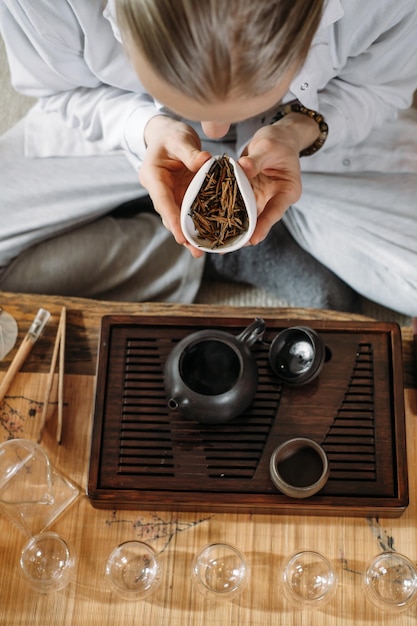 Traditionele chinese theeceremonie serveren en oolong gieten uit een theepot met damp op een donkere achtergrond