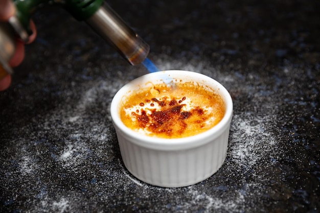 Traditionele creme brulee op rustiek oppervlak en selectieve focus