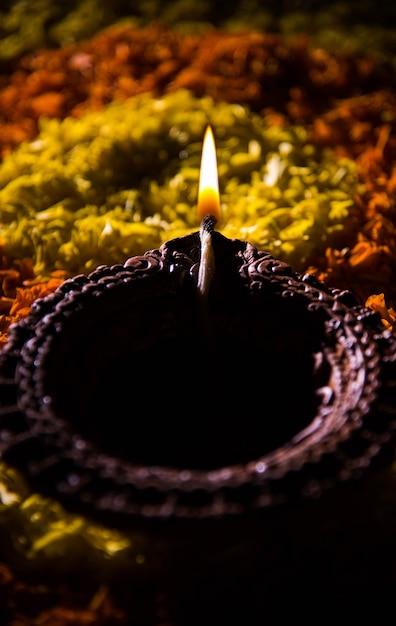 Traditionele diya of olielamp verlicht op kleurrijke rangoli bestaande uit bloemblad, op het festival van lichten genaamd diwali of deepawali, selectieve focus