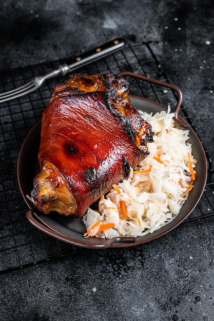 Traditionele Duitse keuken Geroosterde varkensknokkel Schweinshaxe met zuurkool Zwarte achtergrond Bovenaanzicht