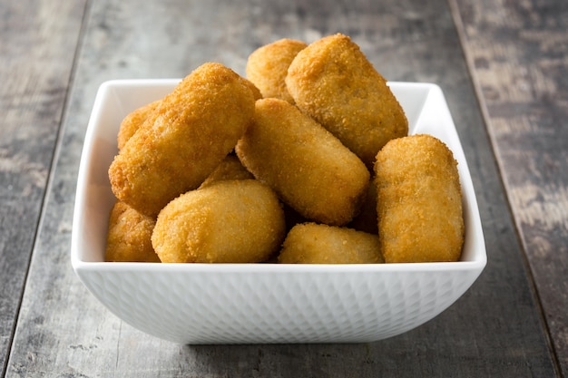 Traditionele gebakken Spaanse kroketten op houten tafel