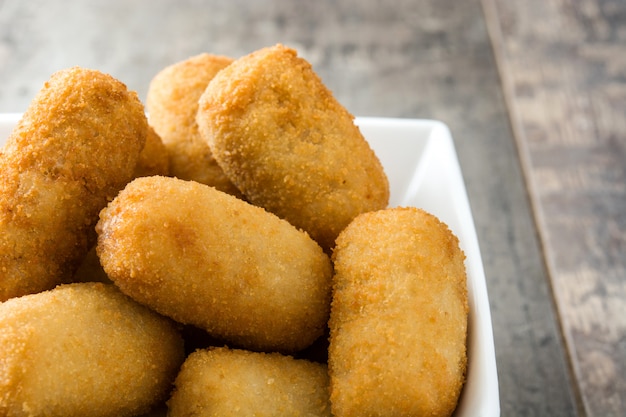 Traditionele gebraden Spaanse kroketten op houten lijst dicht omhoog