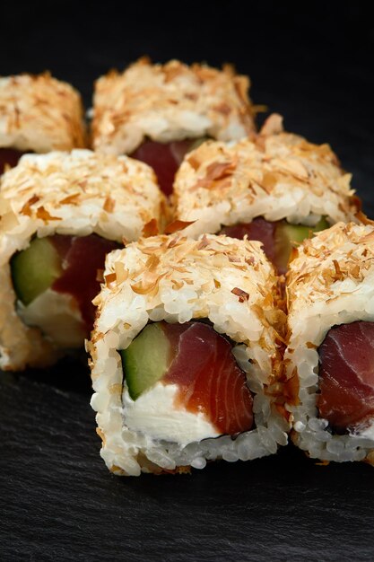 Traditionele heerlijke verse sushi roll set op een zwarte achtergrond Sushi roll met rijst roomkaas avocado zalm sesam Philadelphia Sushi menu Japanse keuken restaurant