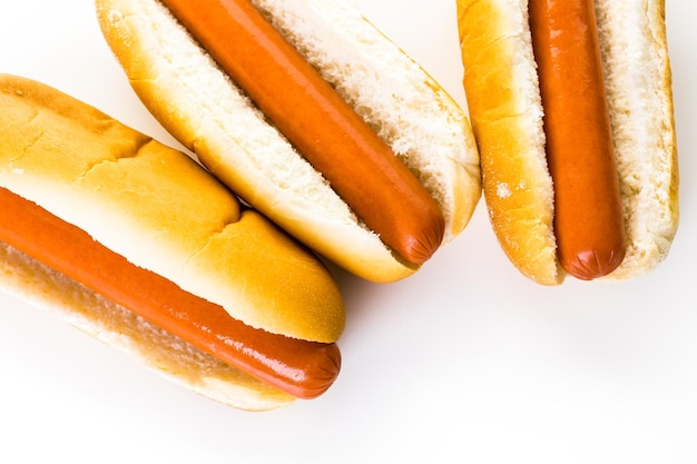 Traditionele hotdogs op een wit hotdogbroodje op een witte achtergrond.