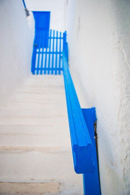 Traditionele huizen met blauwe deur en witte trappen in de smalle straten van Mykonos, Griekenland.