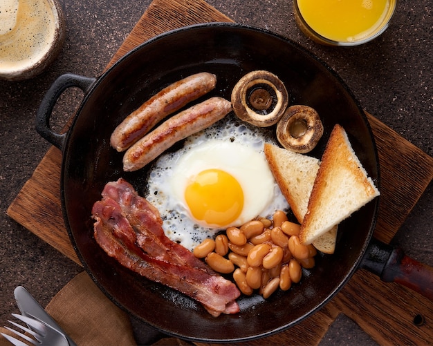 Traditionele Ierse brunch met ham gegrilde worstjes toast champignons bonen en gebakken eieren