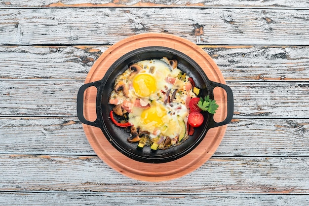 Traditionele Israëlische gerechten Shakshuka Eieren met spek en champignons Op een houten achtergrond Vrije ruimte voor tekst Bovenaanzicht