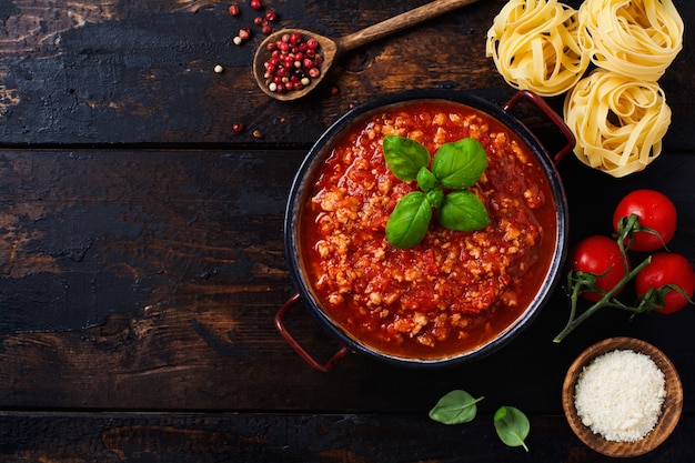 Traditionele Italiaanse Bolognese saus in sauspot een oude donkere houten achtergrond