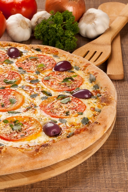 Traditionele Italiaanse pizza met ingrediënten op houten.