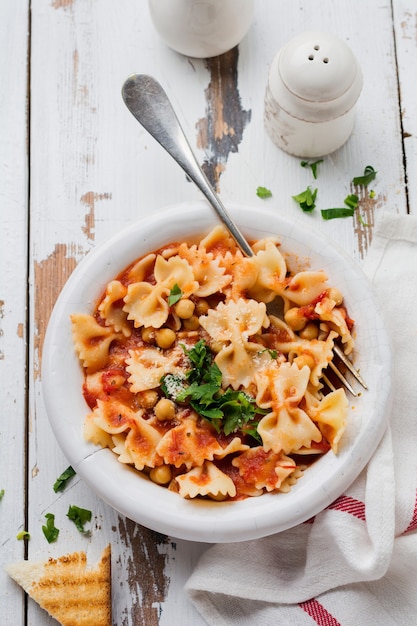 Traditionele Italiaanse schotel, chowder, pottage, pasta e ceci geserveerd in oude plaat op oude houten achtergrond. Rustieke stijl. Bovenaanzicht.