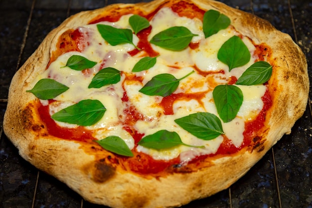 Traditionele Italiaanse vera Margherita-pizza met mozarella en basilicum die op witte achtergrond wordt geïsoleerd