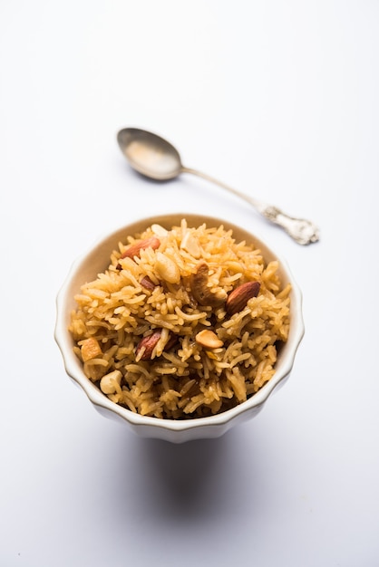 Traditionele Jaggery Rice of Gur wale chawal in het Hindi, geserveerd in een kom met lepel. selectieve focus