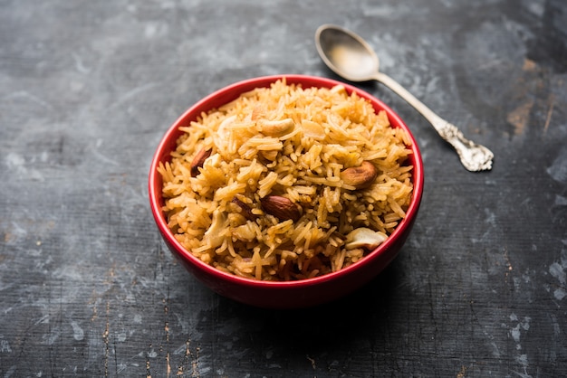 Traditionele Jaggery Rice of Gur wale chawal in het Hindi, geserveerd in een kom met lepel. selectieve focus