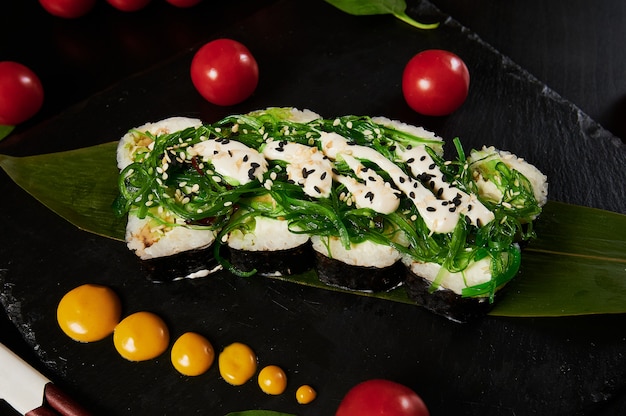 Traditionele Japanse gerechten - sushi, broodjes en saus op een zwarte achtergrond.