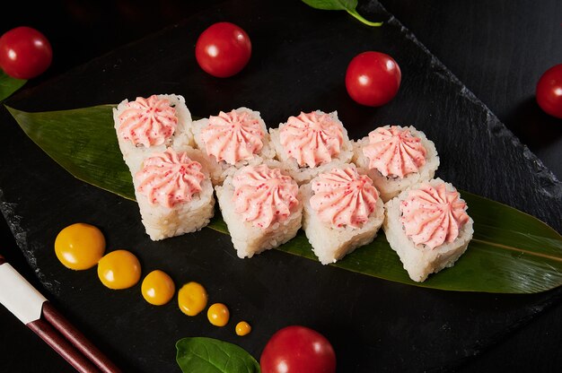 Traditionele Japanse gerechten - sushi, broodjes en saus op een zwarte achtergrond.