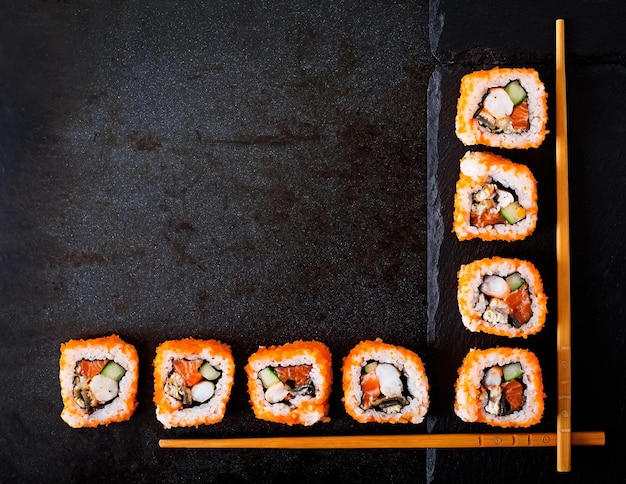 Traditionele Japanse sushi rollen en eetstokjes voor sushi op een donkere achtergrond