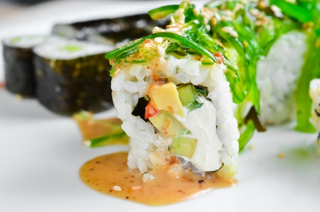 Traditionele japanse sushi rolt op een witte plaat bovenaanzicht aziatisch eten op een witte achtergrond