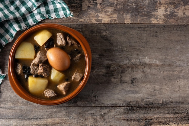 Traditionele Joodse cholent in kom op houten tafel