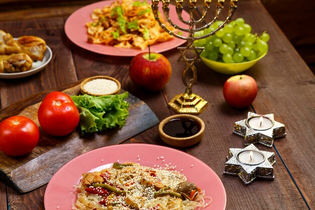 Foto traditionele joodse gerechten op de gedekte tafel fruit brandende kaarsen en menora