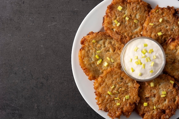 Traditionele Joodse latkes of aardappelpannenkoekjes op zwart